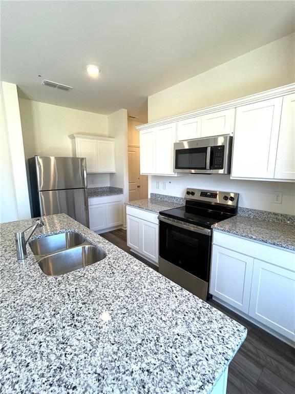 24 Rowlett Place Winder, GA 30680 - Photo 5 of 17 a kitchen with granite countertop a sink and a stove top oven