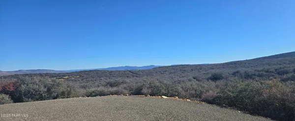 a view of a dry yard with mountains in the background