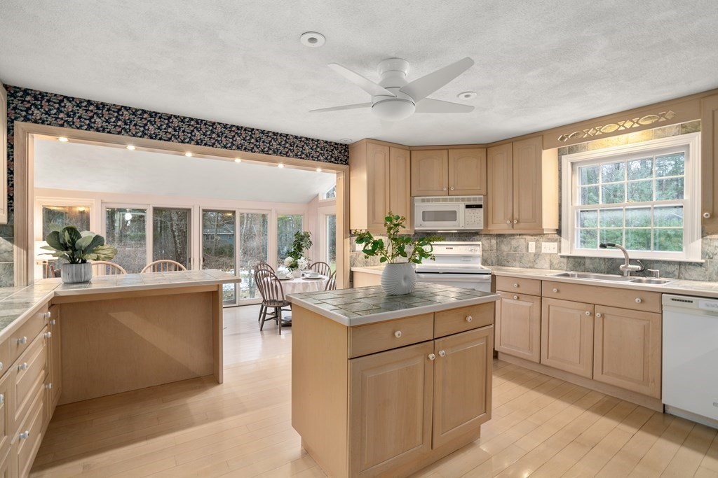 62 Rambling Road Sudbury, MA 01776 - Photo 15 of 38 a kitchen with kitchen island granite countertop a sink and white cabinets
