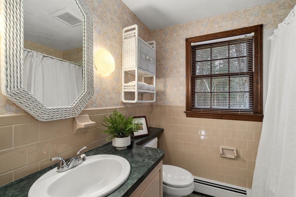 62 Rambling Road Sudbury, MA 01776 - Photo 23 of 38 a bathroom with a sink a toilet and a mirror