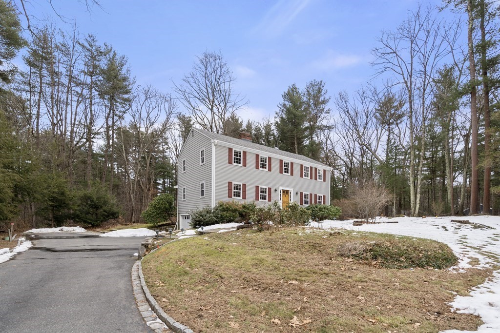 62 Rambling Road Sudbury, MA 01776 - Photo 29 of 38 a view of a white house with a yard covered with snow