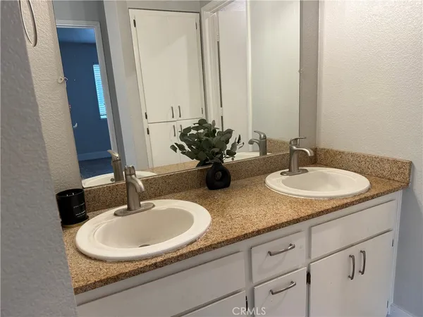a bathroom with double sink and a mirror