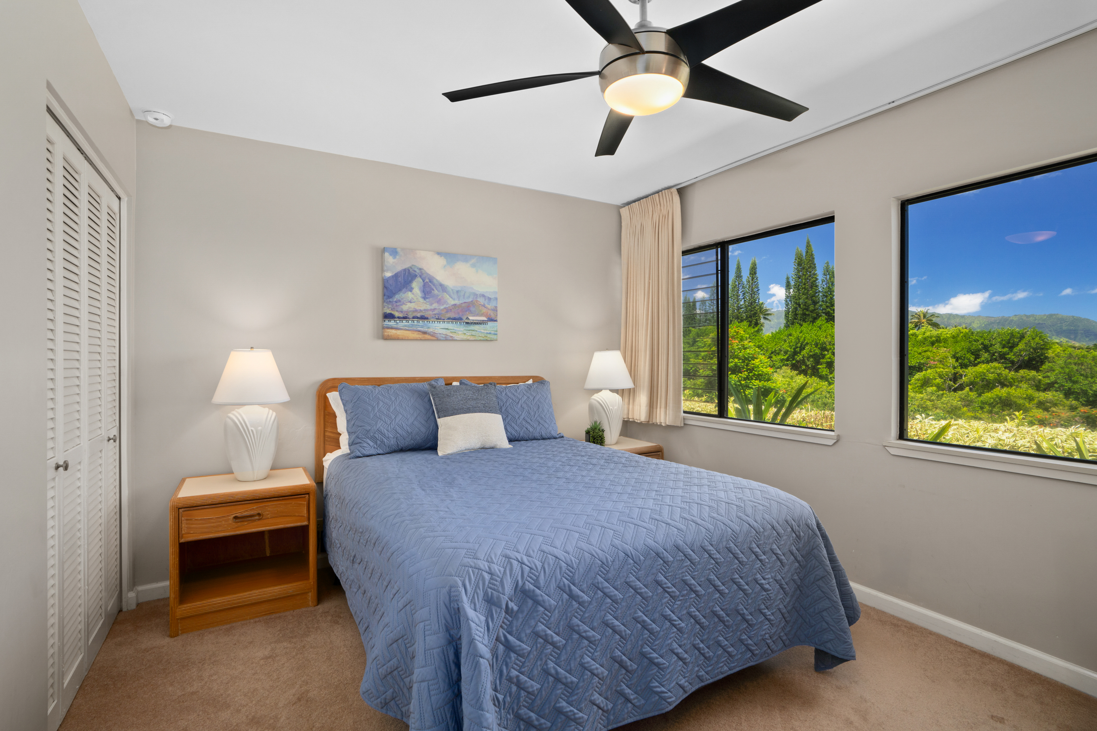 3830 Edward Road, Unit 12D Princeville, HI 96722 - Photo 17 of 30 a bedroom with a bed and a chandelier