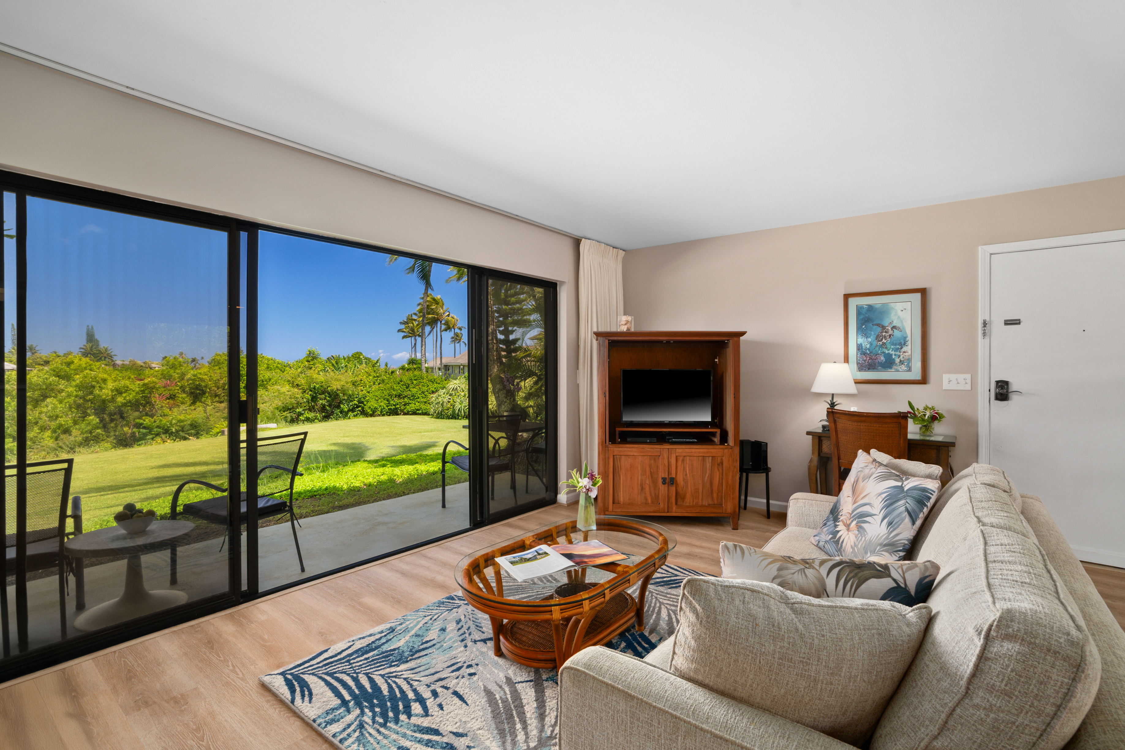 3830 Edward Road, Unit 12D Princeville, HI 96722 - Photo 5 of 30 a living room with furniture and a flat screen tv