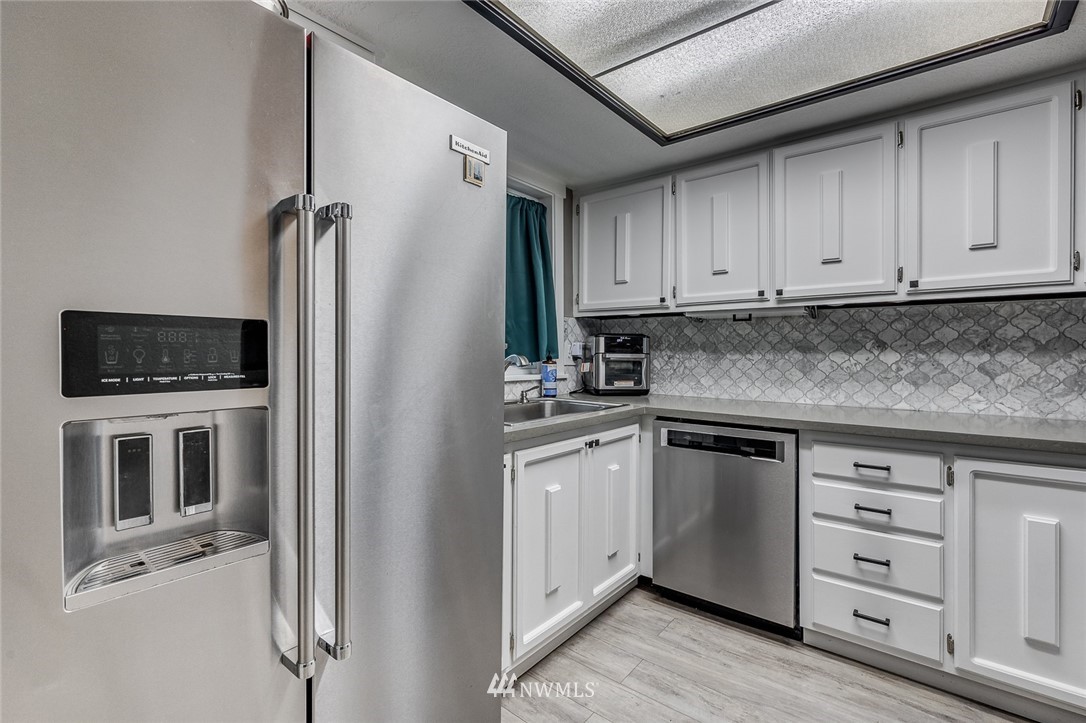 6918 Lower Ridge Road, Unit B Everett, WA 98203 - Photo 6 of 25 a kitchen with stainless steel appliances granite countertop a refrigerator and a stove top oven