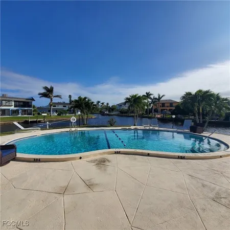 a swimming pool with outdoor seating and plants