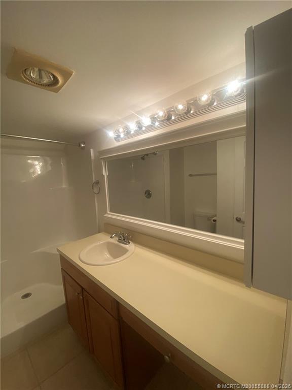 8227 Southeast Croft Circle Hobe Sound, FL 33455 - Photo 12 of 18 a bathroom with a sink a large mirror and a shower