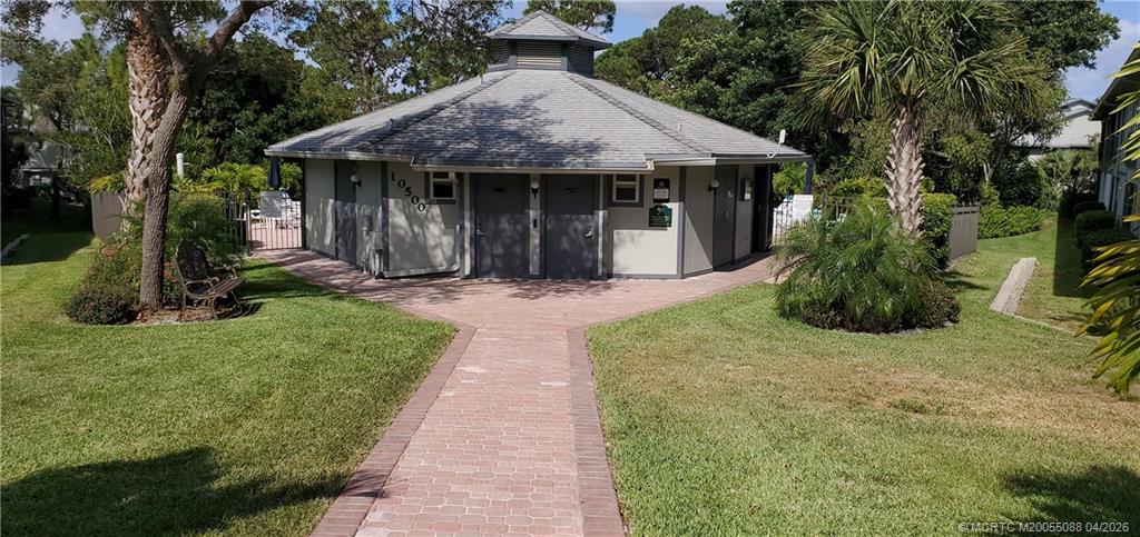 8227 Southeast Croft Circle Hobe Sound, FL 33455 - Photo 18 of 18 a front view of a house with a garden