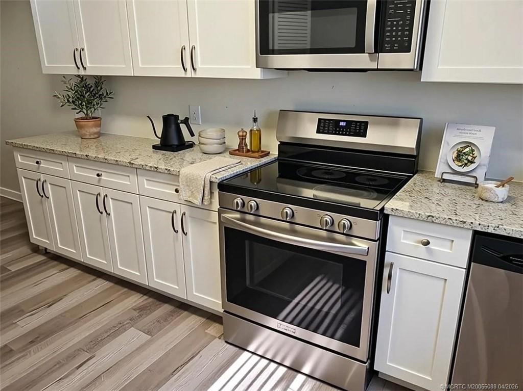 8227 Southeast Croft Circle Hobe Sound, FL 33455 - Photo 2 of 18 a kitchen with granite countertop a stove sink and cabinets