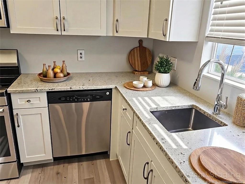8227 Southeast Croft Circle Hobe Sound, FL 33455 - Photo 3 of 18 a kitchen with a sink a stove and cabinets