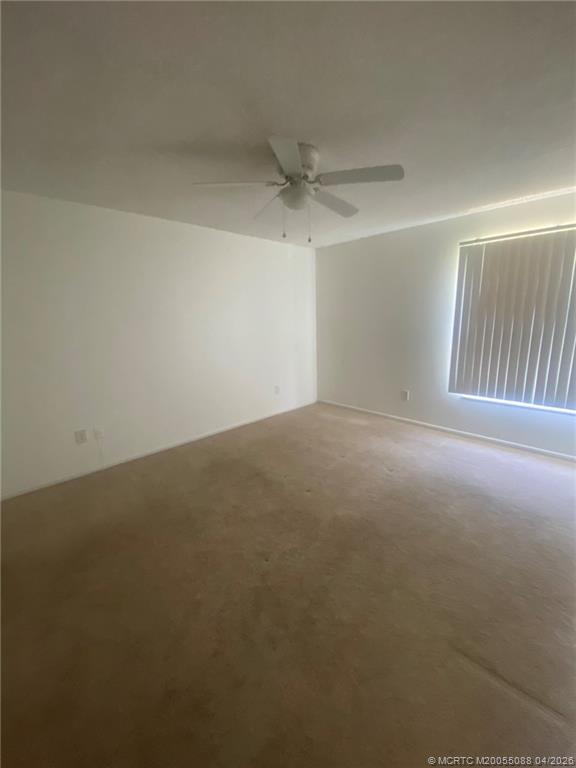 8227 Southeast Croft Circle Hobe Sound, FL 33455 - Photo 8 of 18 an empty room with windows and fan