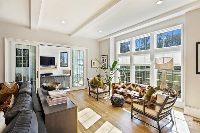 a living room with furniture large windows and a flat screen tv