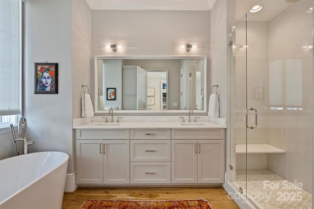 a bathroom with a tub a sink and mirrors