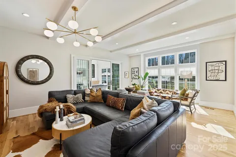 a living room with furniture a large window and a chandelier