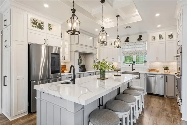 a kitchen with stainless steel appliances kitchen island granite countertop a table chairs and a refrigerator