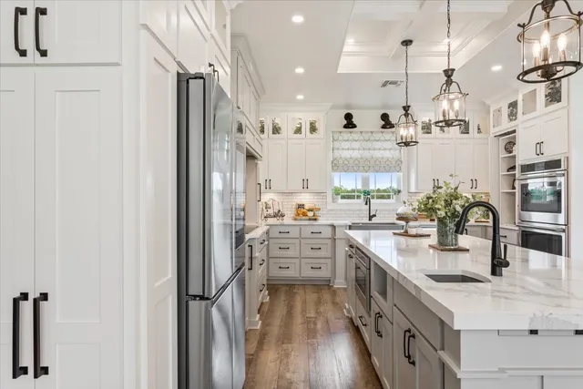 a view of a kitchen with kitchen island a counter top space a sink stainless steel appliances and cabinets