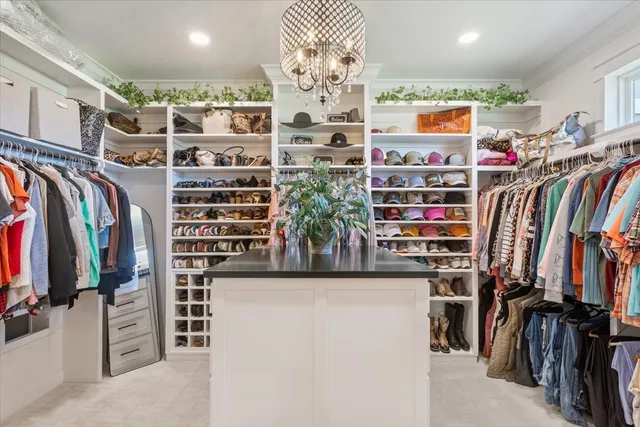 a view of walk in closet with clothes and shoes