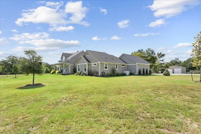 a house view with swimming pool and trees in the background