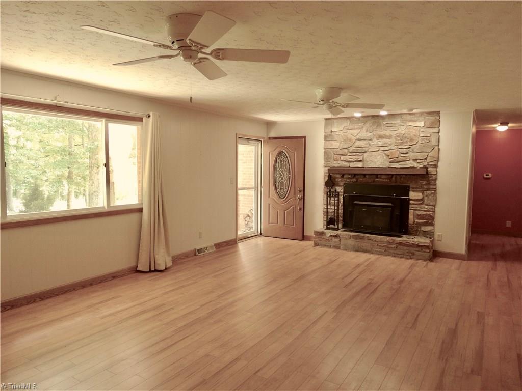 5044 Sitka Road Walkertown, NC 27051 - Photo 8 of 15 Spacious living room with wood store. There is plenty of room for entertaining here! Easy to care for floors and abundant sunshine from the large windows!