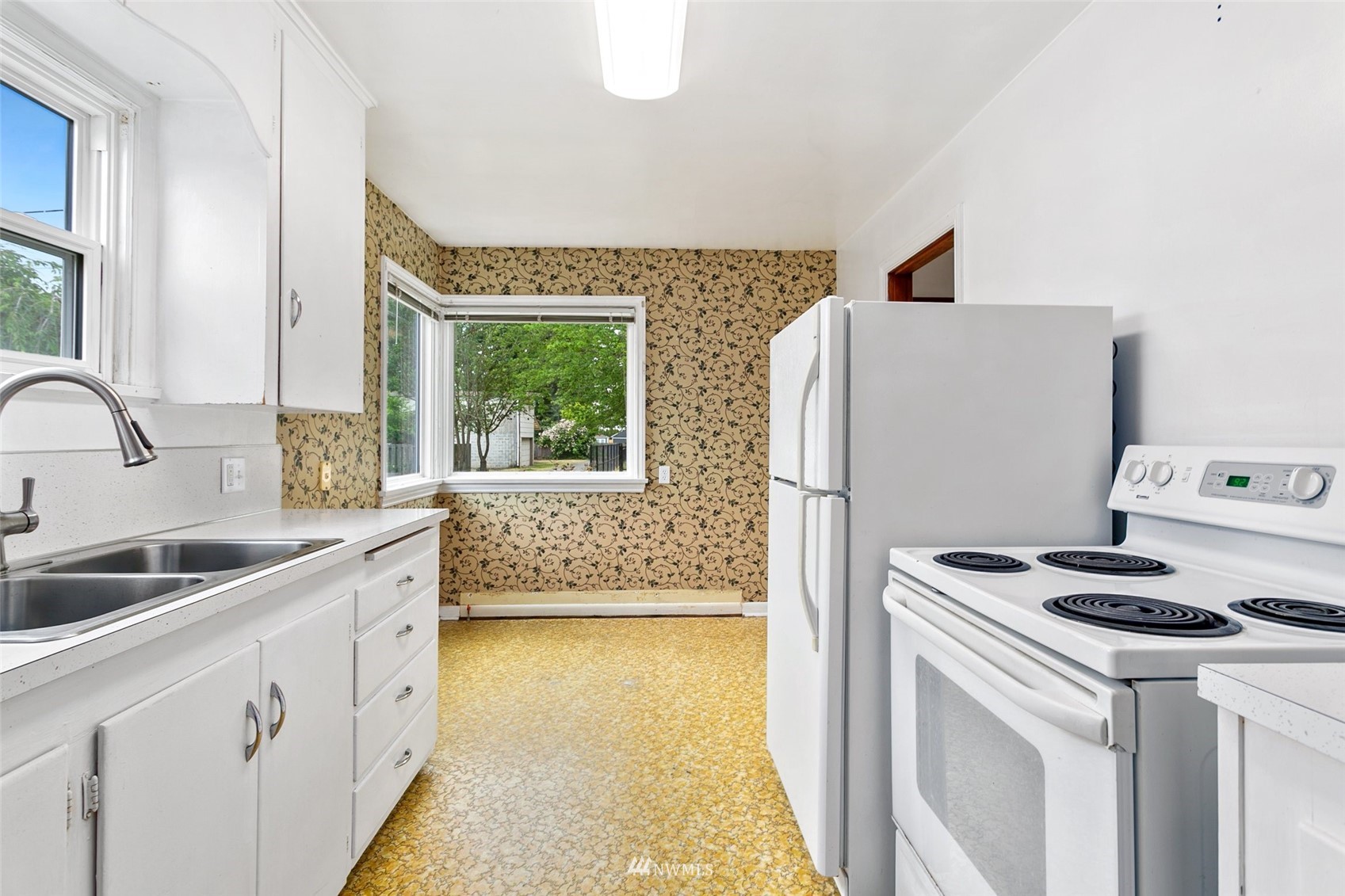 218 West Crow Street Kent, WA 98032 - Photo 11 of 25 a kitchen with a refrigerator sink and white cabinets