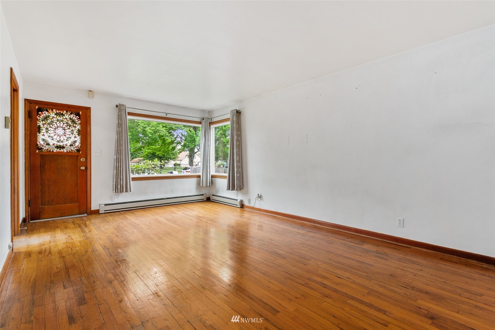 218 West Crow Street Kent, WA 98032 - Photo 7 of 25 a view of an empty room with wooden floor and a window