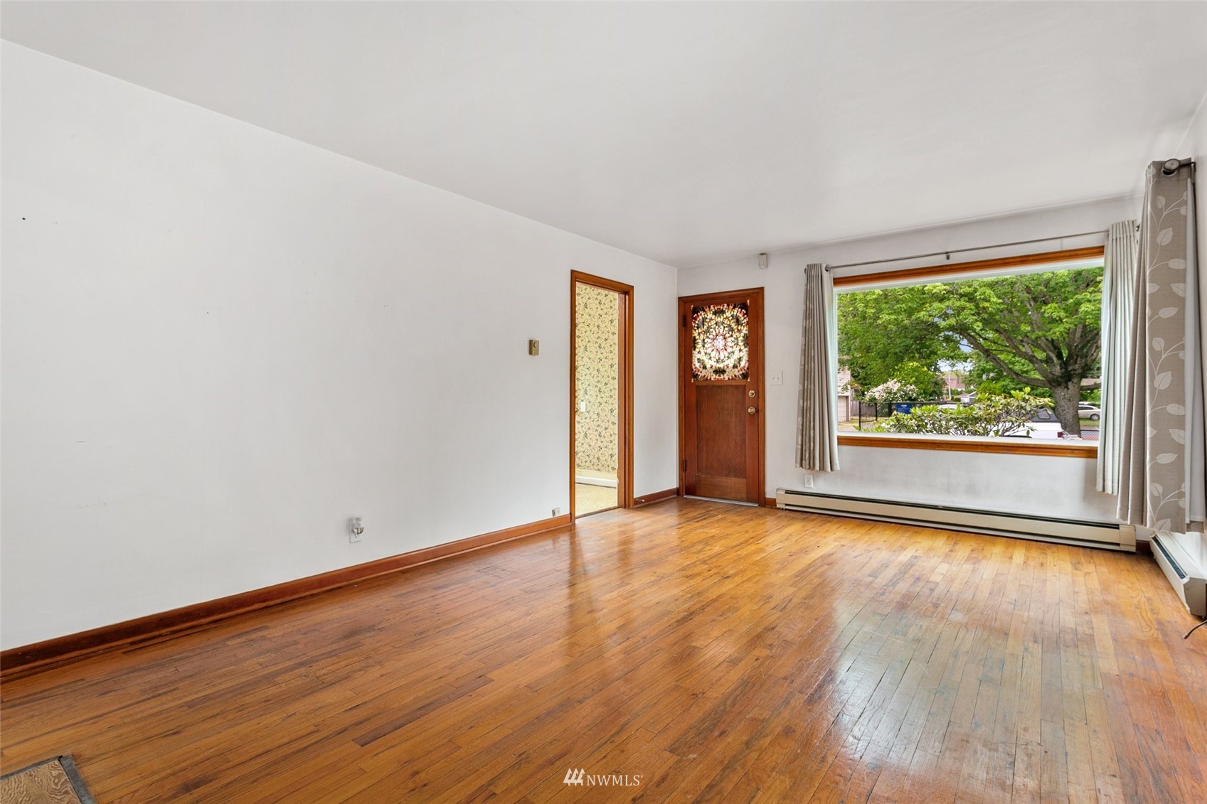 218 West Crow Street Kent, WA 98032 - Photo 8 of 25 a view of an empty room with wooden floor and a window