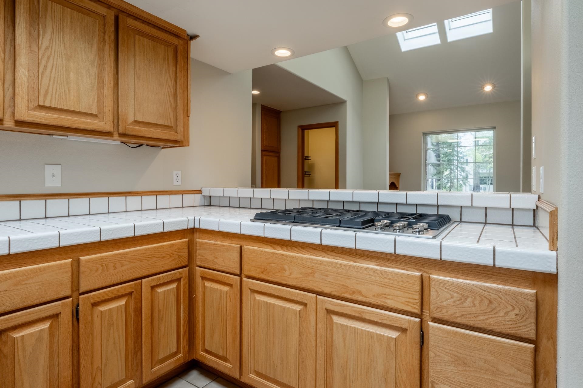 272 Ridge Way Mammoth Lakes, CA 93546 - Photo 27 of 55 Kitchen featuring light wood cabinetry, white tile countertops, a built-in cooktop, and recessed lighting