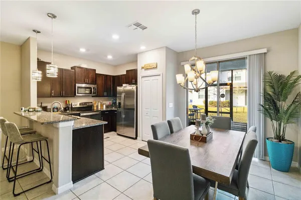 a kitchen with a refrigerator a stove a sink dishwasher with a dining table and chairs