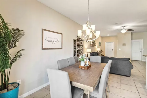 a dining room with furniture a chandelier and wooden floor