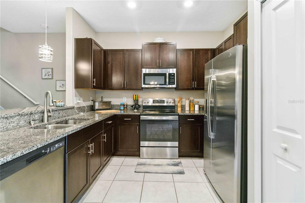 14339 Easy Goer Street Ruskin, FL 33573 - Photo 17 of 49 a kitchen with stainless steel appliances granite countertop a refrigerator and a sink