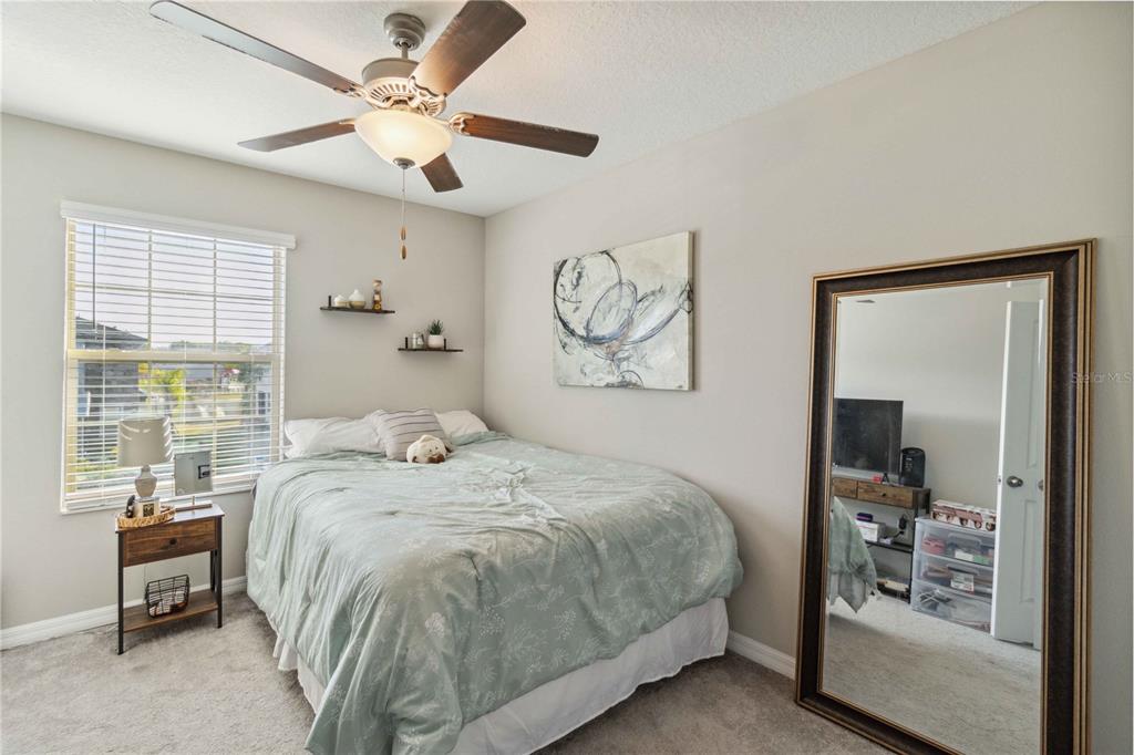 14339 Easy Goer Street Ruskin, FL 33573 - Photo 27 of 49 a bedroom with a large bed and a chandelier