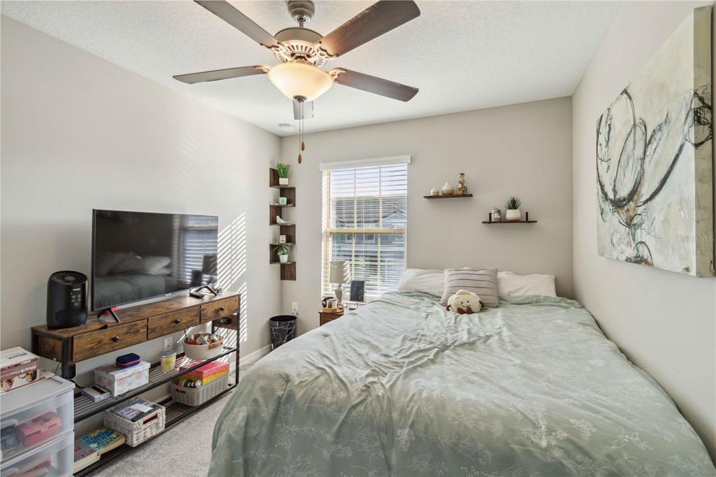 14339 Easy Goer Street Ruskin, FL 33573 - Photo 28 of 49 a bedroom with a bed and a flat screen tv