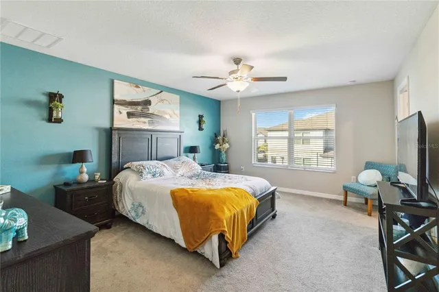 a spacious bedroom with a bed and a chandelier