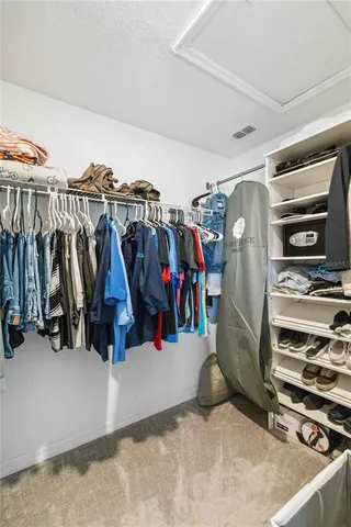 a view of walk in closet with clothes