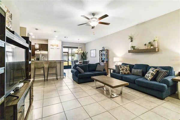 a living room with furniture a flat screen tv and kitchen view