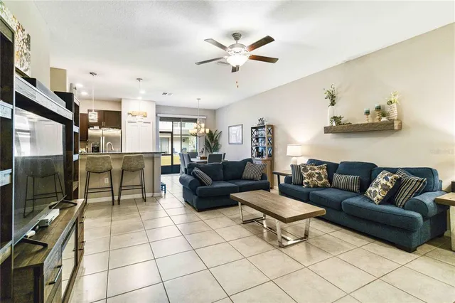 a living room with furniture a flat screen tv and kitchen view