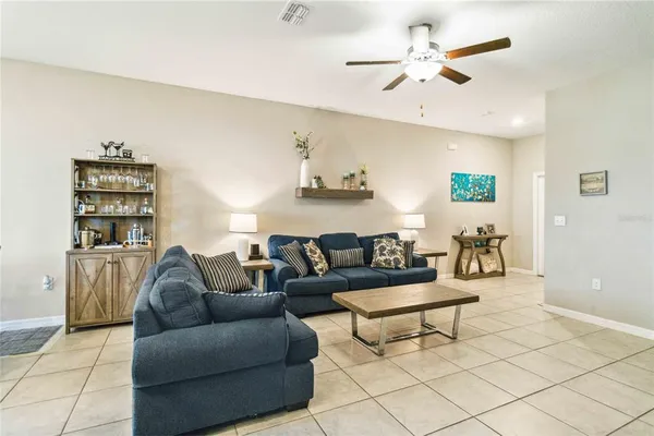 a living room with furniture and a ceiling fan