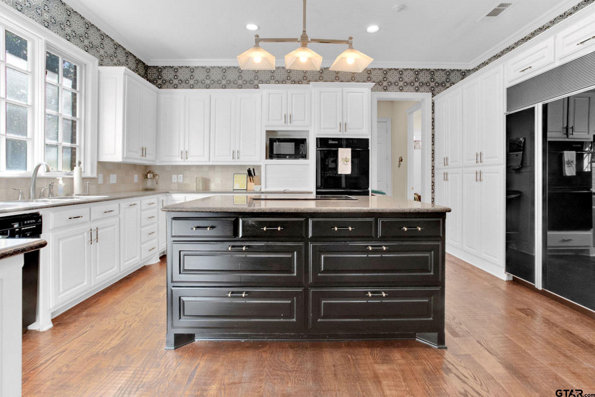 408 East Jolly Street Palestine, TX 75801 - Photo 20 of 48 a kitchen with a sink dishwasher a stove and a microwave oven with cabinets