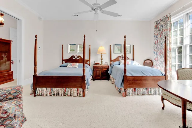 a bedroom with two beds and a large mirror