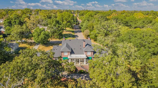 an aerial view of a house with swimming pool and garden space