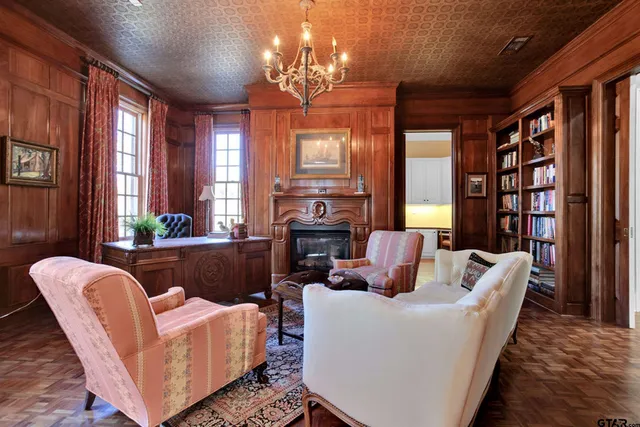 a living room with furniture a chandelier and a fireplace