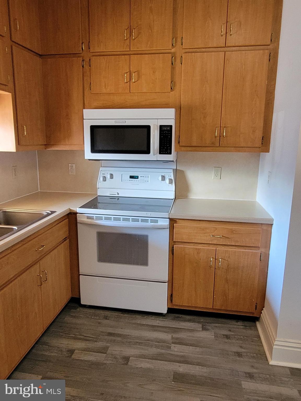 1801 South Main Street, Unit 6 Bechtelsville, PA 19505 - Photo 3 of 20 a kitchen with stainless steel appliances white cabinets and a wooden floor