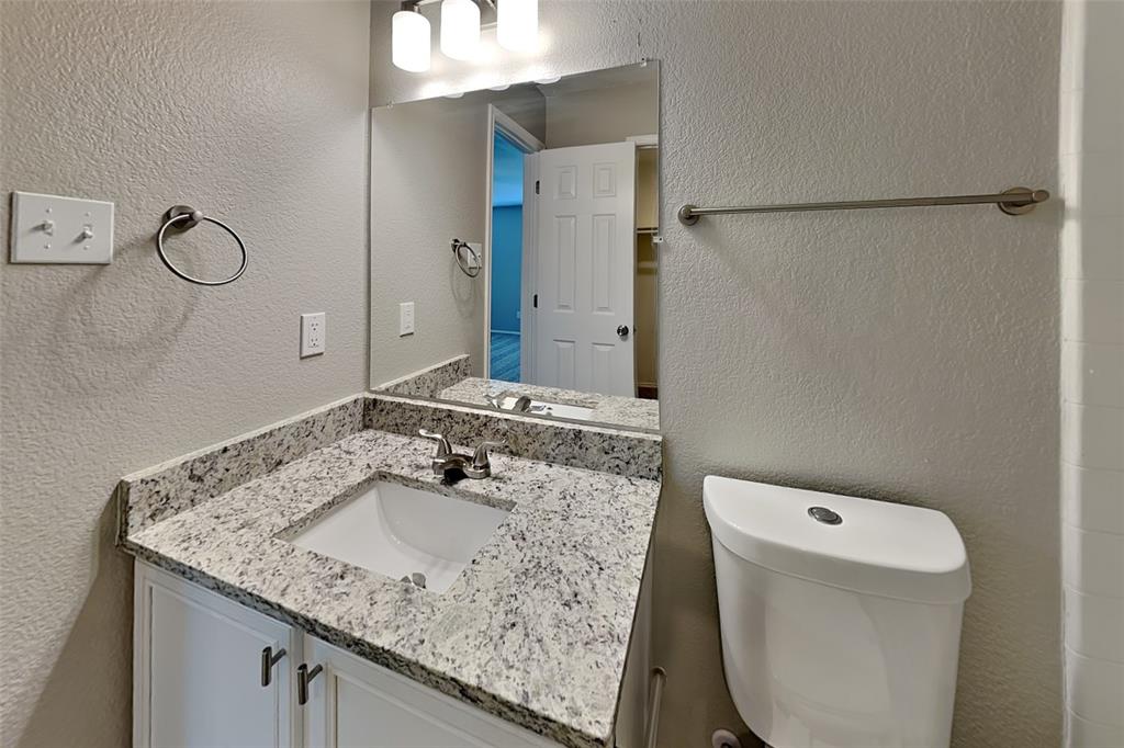 1420 Waterford Drive Little Elm, TX 75068 - Photo 13 of 23 a bathroom with a granite countertop sink a toilet and a mirror