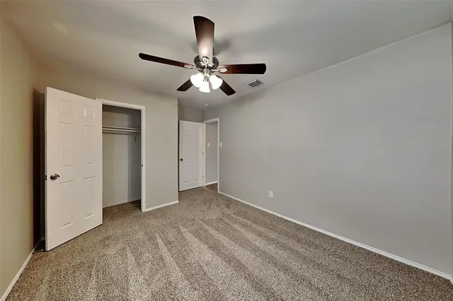 a view of empty room with ceiling fan