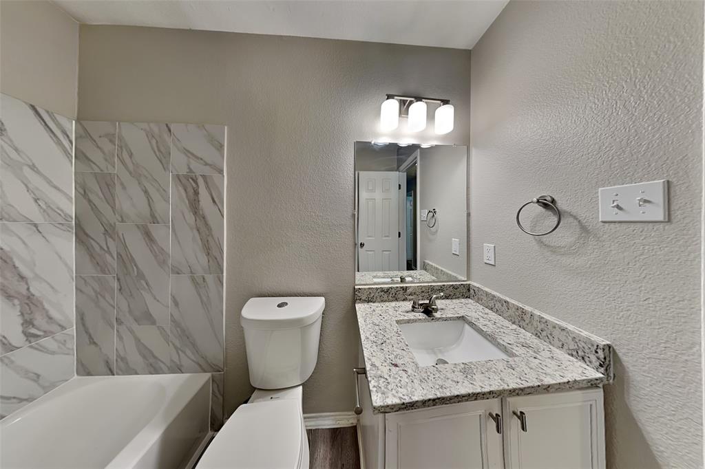 1420 Waterford Drive Little Elm, TX 75068 - Photo 21 of 23 a bathroom with a granite countertop sink a toilet and mirror