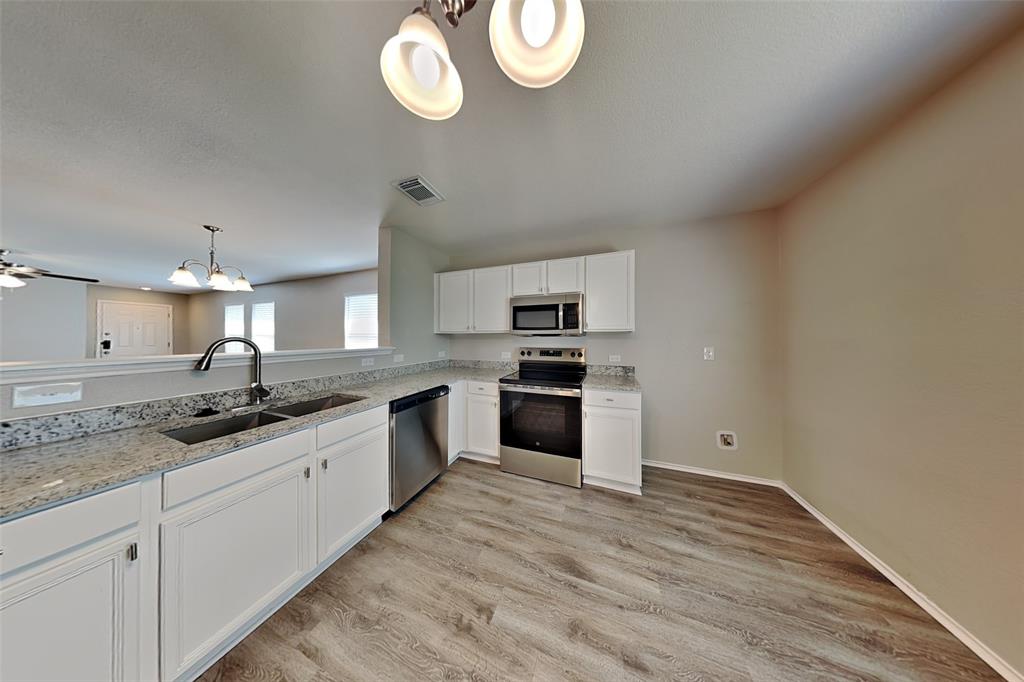 1420 Waterford Drive Little Elm, TX 75068 - Photo 4 of 23 a large kitchen with a sink and dishwasher a stove with wooden floor