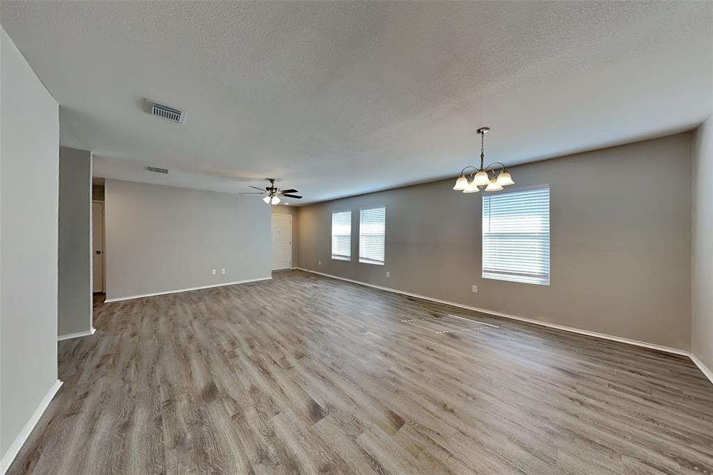 1420 Waterford Drive Little Elm, TX 75068 - Photo 6 of 23 an empty room with wooden floor and chandelier