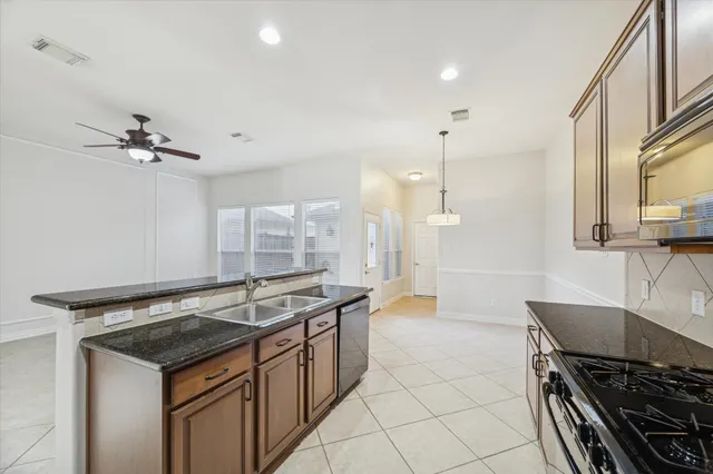 a kitchen that has a sink a stove and a table with chairs
