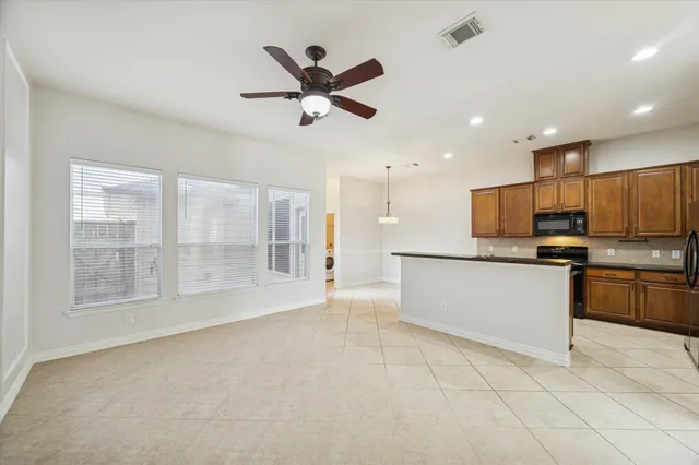 a large kitchen with stainless steel appliances granite countertop a stove and a refrigerator
