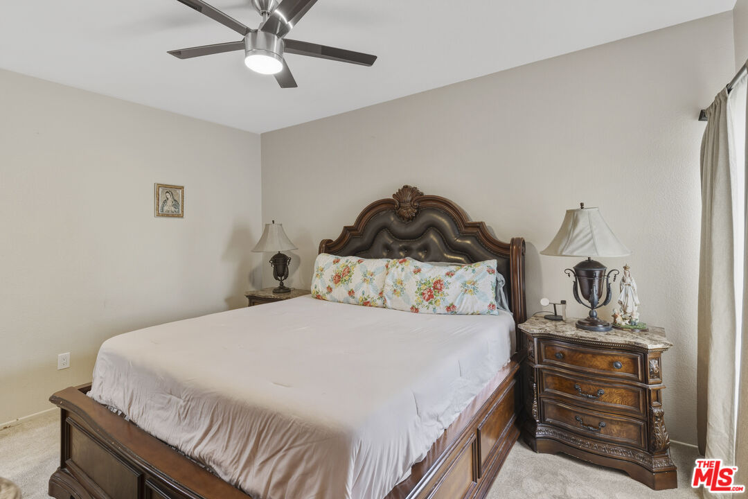47395 Monroe Street, Unit 254 Indio, CA 92201 - Photo 13 of 21 a bedroom with a bed and ceiling fan